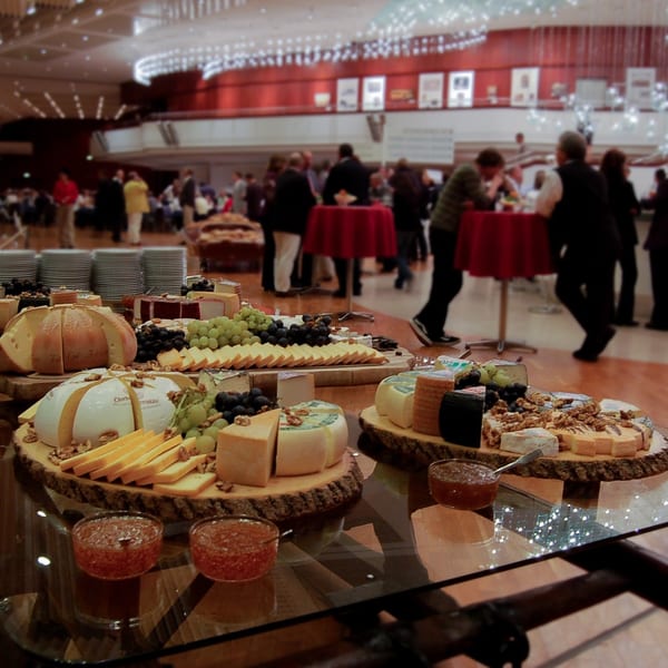 A large cheese and fruit platter with grapes, walnuts, and jams, at a Market Street Grill event.